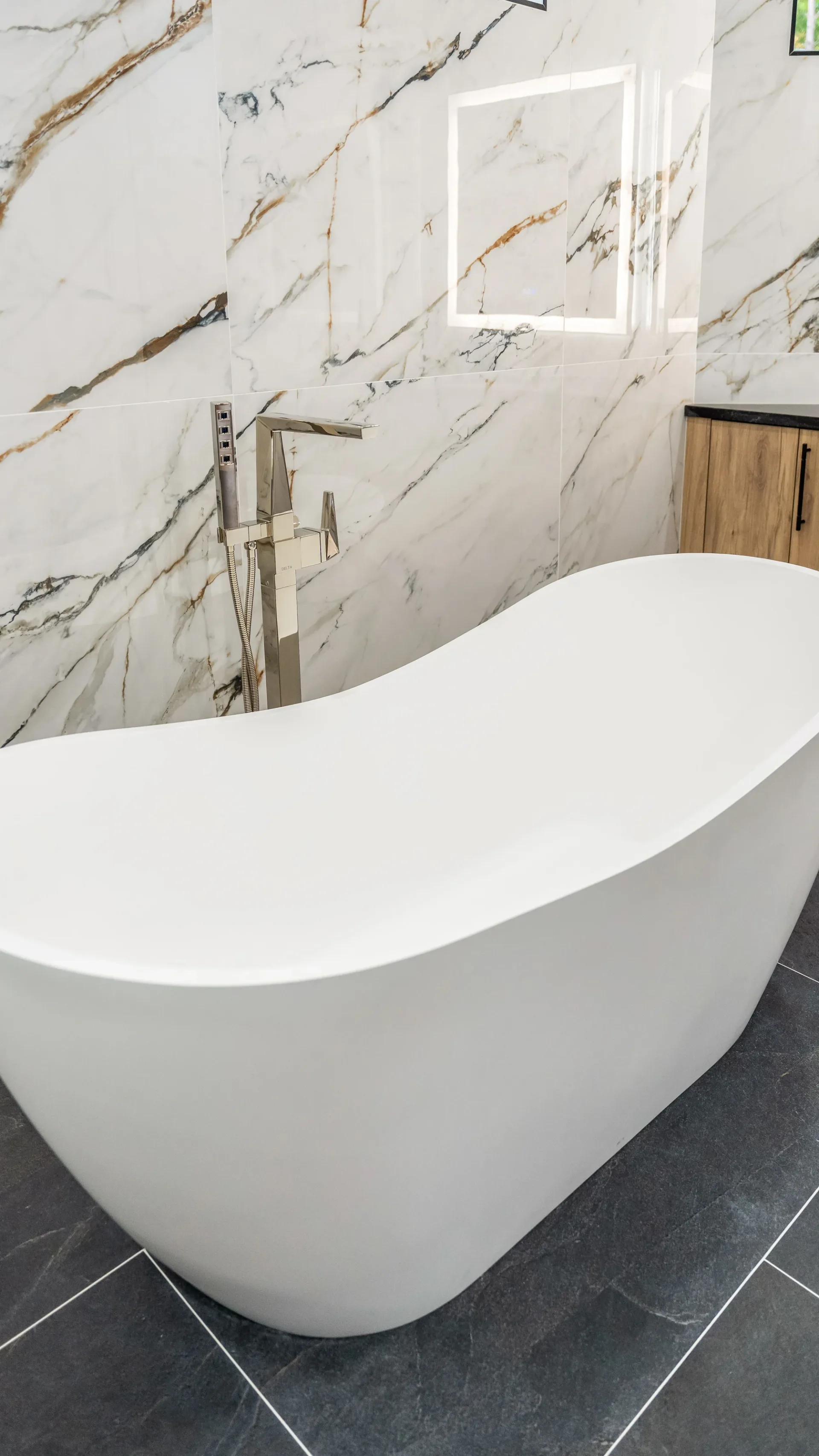 Luxury spa bathroom with marble tiles and designer fixtures in The Emerald Mediterranean revival home at 210 16th Ave NE, Naples FL by XL Homes custom home builder