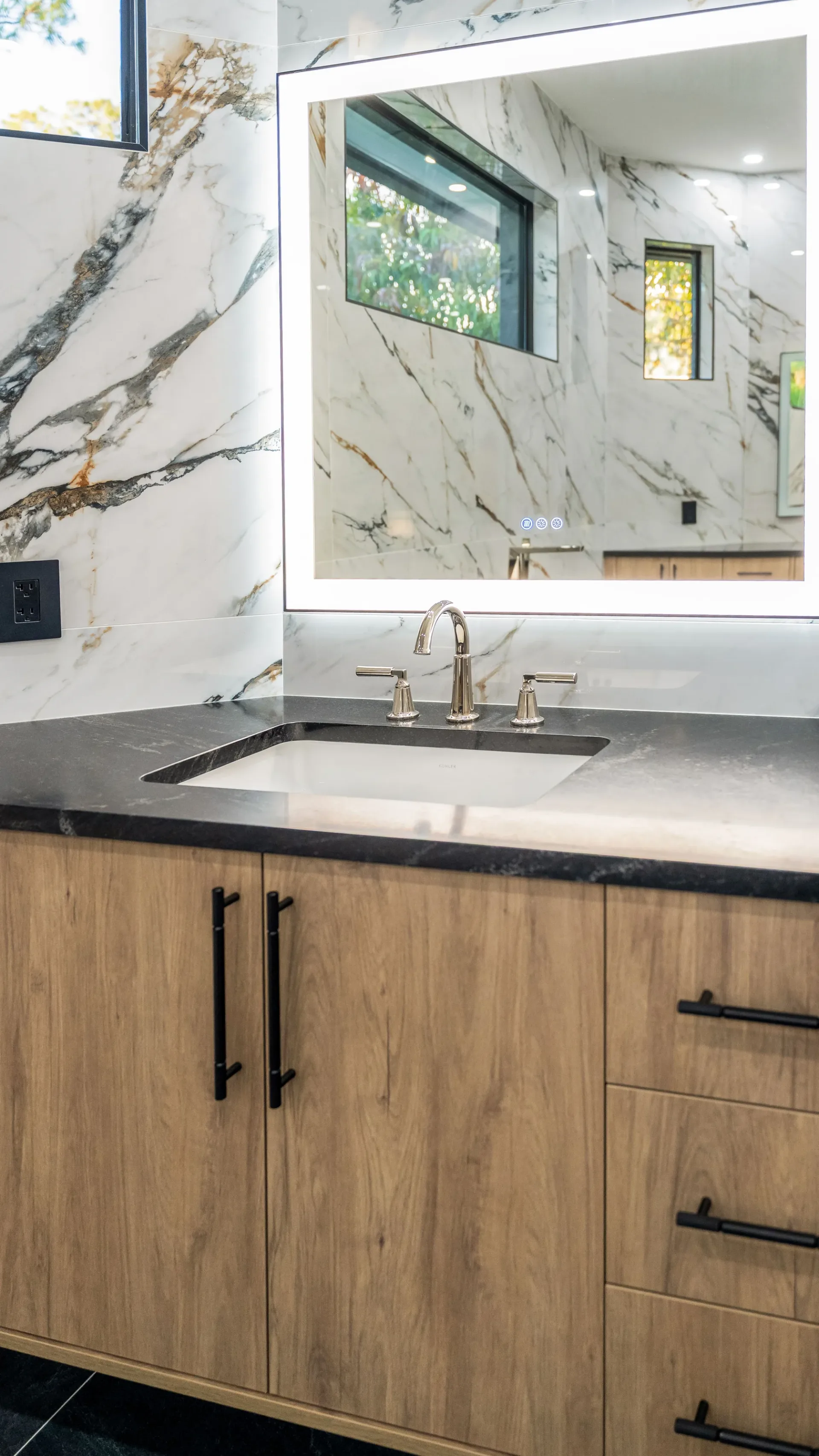 Luxury spa bathroom with marble tiles and designer fixtures in The Emerald Mediterranean revival home at 210 16th Ave NE, Naples FL by XL Homes custom home builder