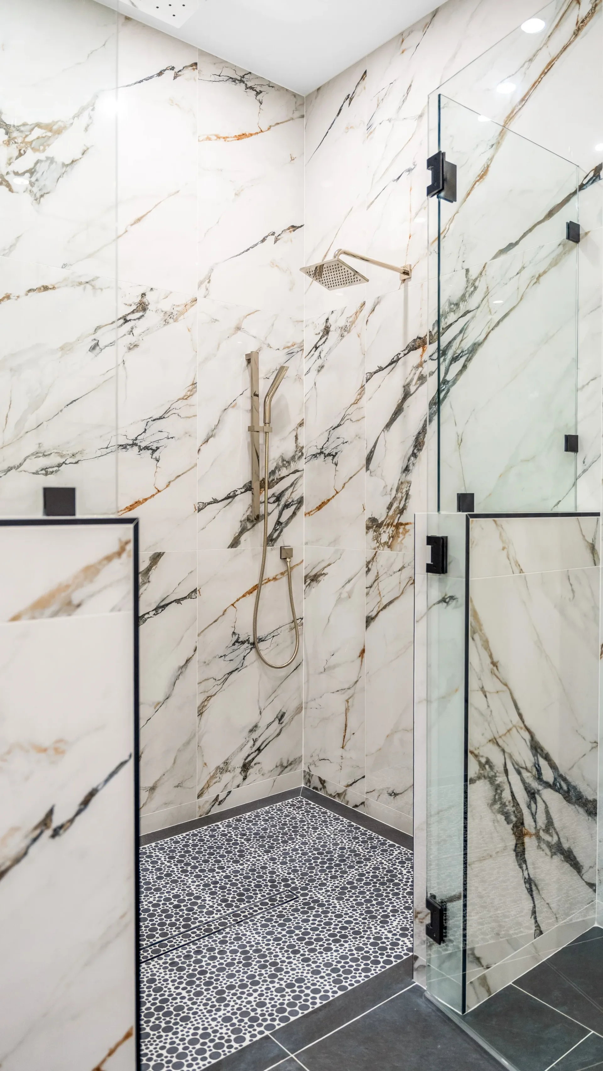 Luxury spa bathroom with marble tiles and designer fixtures in The Emerald Mediterranean revival home at 210 16th Ave NE, Naples FL by XL Homes custom home builder