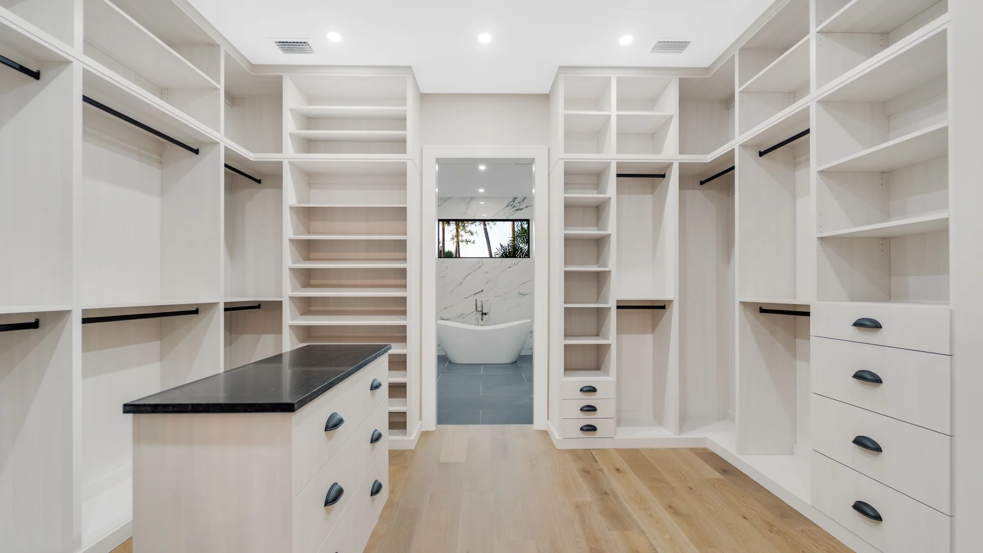 Custom walk-in closet with LED lighting and organization system in The Emerald Mediterranean revival home at 210 16th Ave NE, Naples FL by XL Homes custom home builder