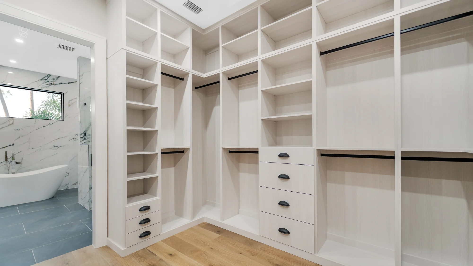Custom walk-in closet with LED lighting and organization system in The Emerald Mediterranean revival home at 210 16th Ave NE, Naples FL by XL Homes custom home builder