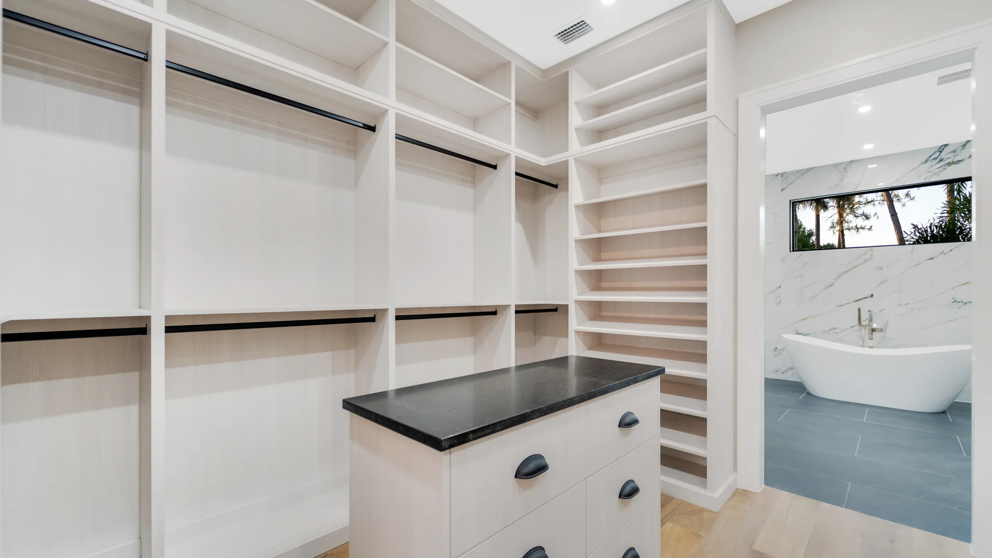 Custom walk-in closet with LED lighting and organization system in The Emerald Mediterranean revival home at 210 16th Ave NE, Naples FL by XL Homes custom home builder