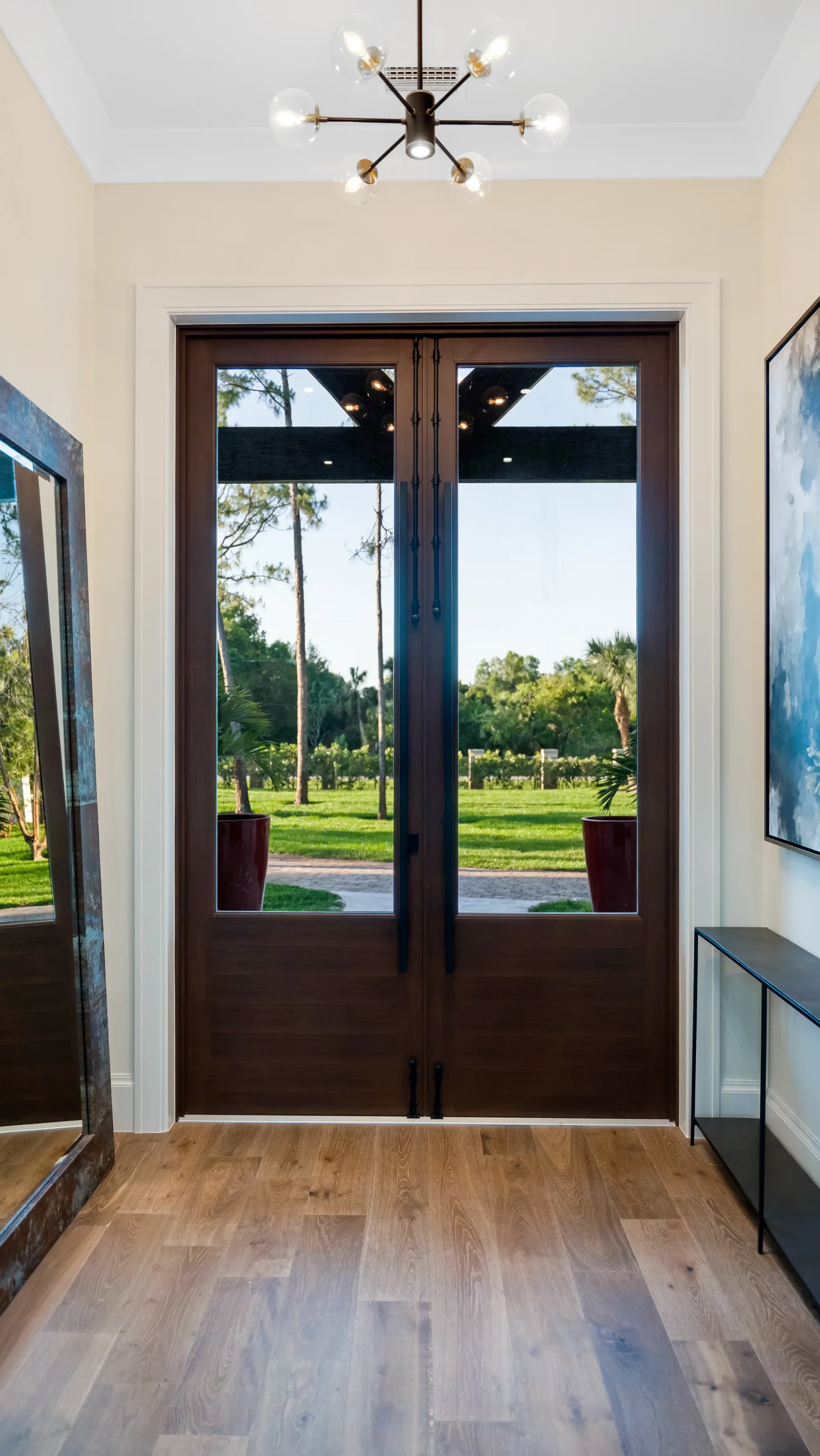 Grand entryway with statement door and decorative tile in The Emerald Mediterranean revival home at 210 16th Ave NE, Naples FL by XL Homes custom home builder