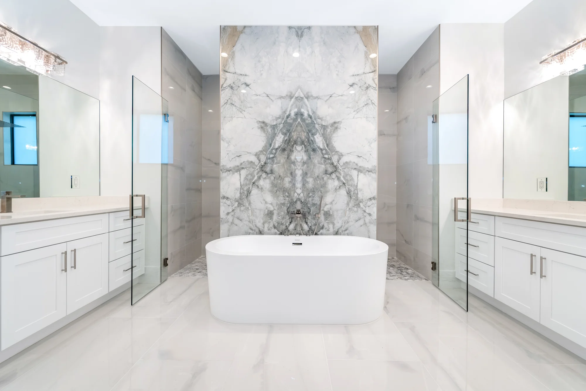 Luxury spa bathroom with marble tiles and designer fixtures in Sunset Golf modern golf estate home at 524 22nd Ave NW, Naples FL by XL Homes custom home builder