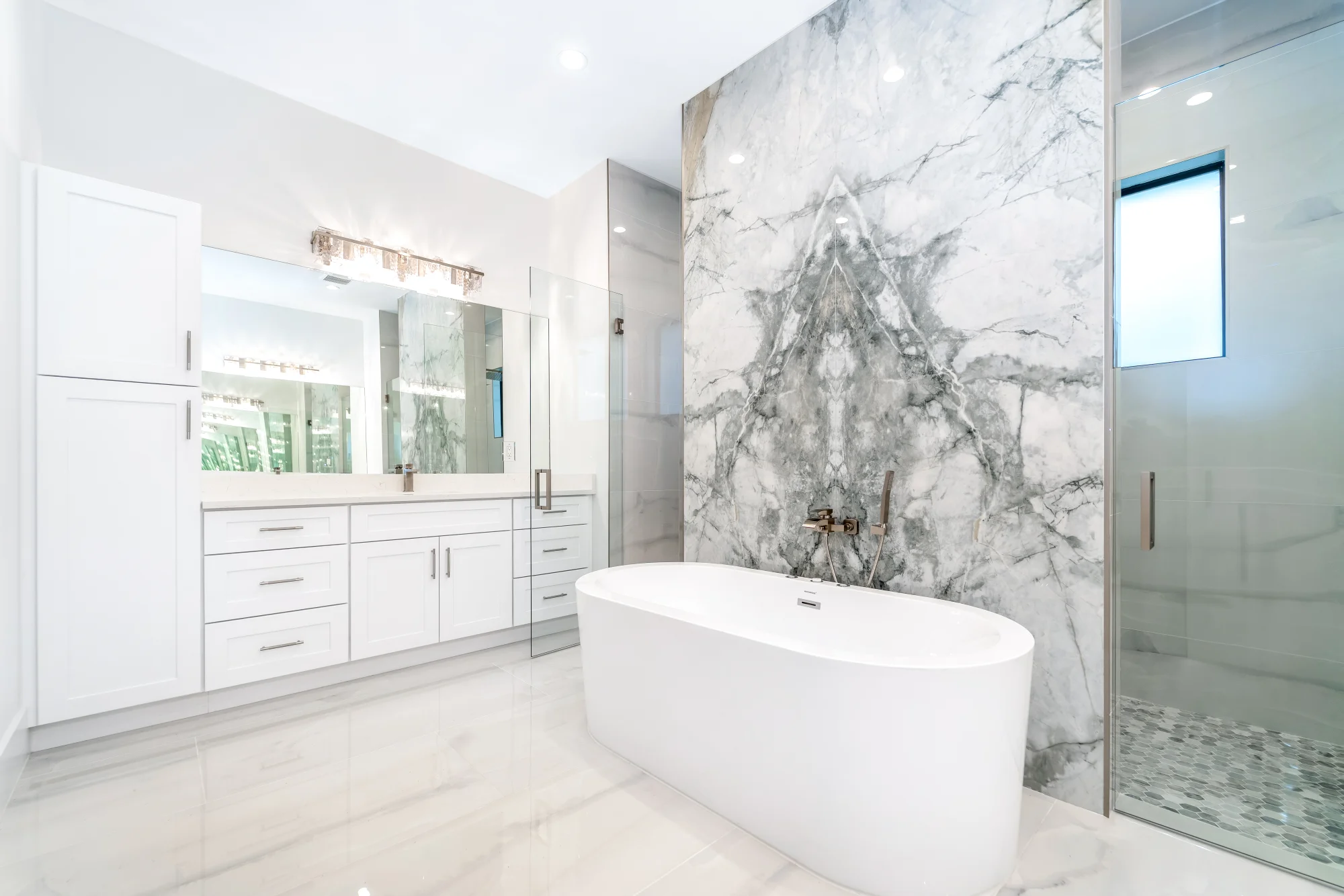 Luxury spa bathroom with marble tiles and designer fixtures in Sunset Golf modern golf estate home at 524 22nd Ave NW, Naples FL by XL Homes custom home builder