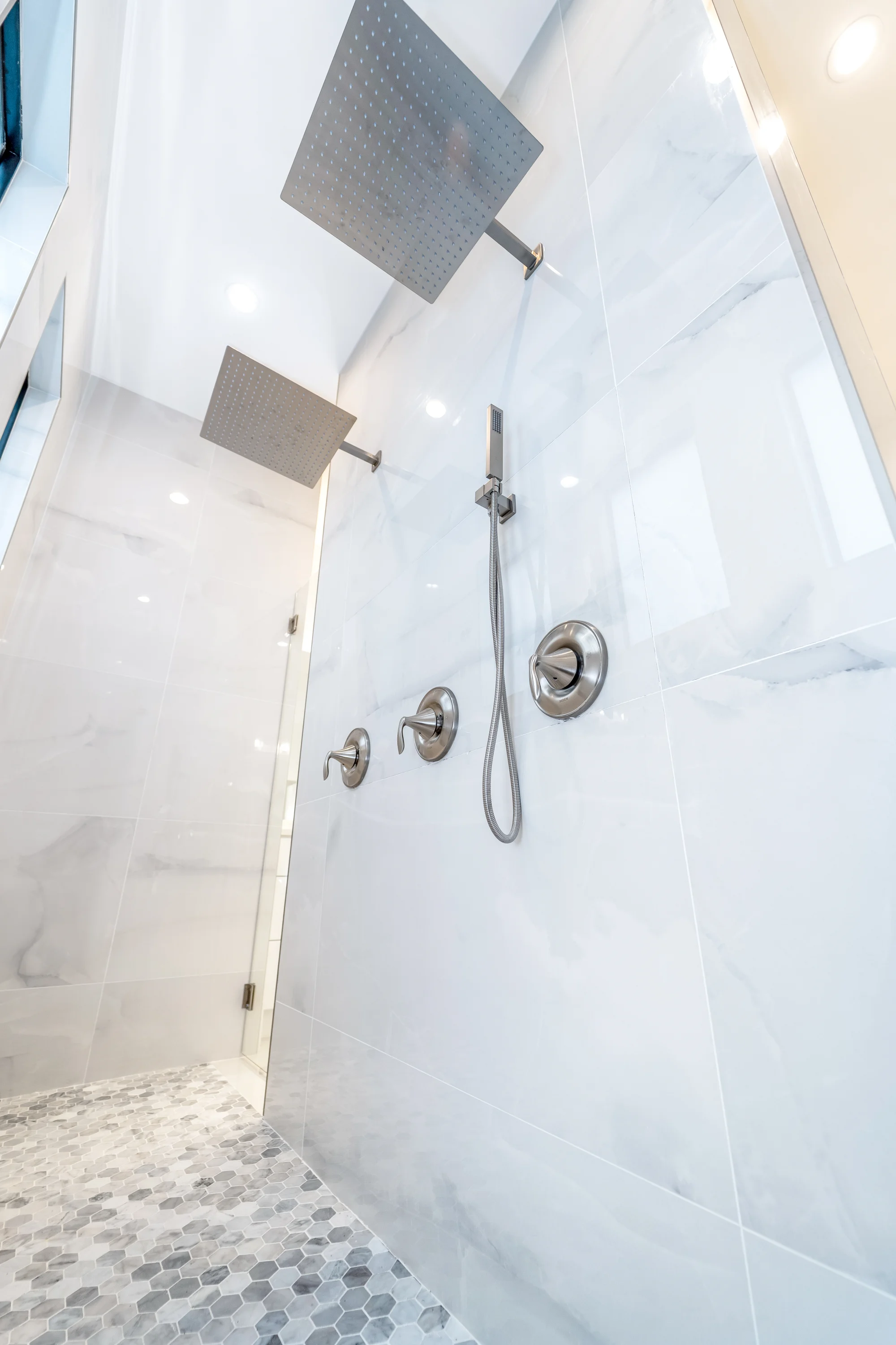 Luxury spa bathroom with marble tiles and designer fixtures in Sunset Golf modern golf estate home at 524 22nd Ave NW, Naples FL by XL Homes custom home builder