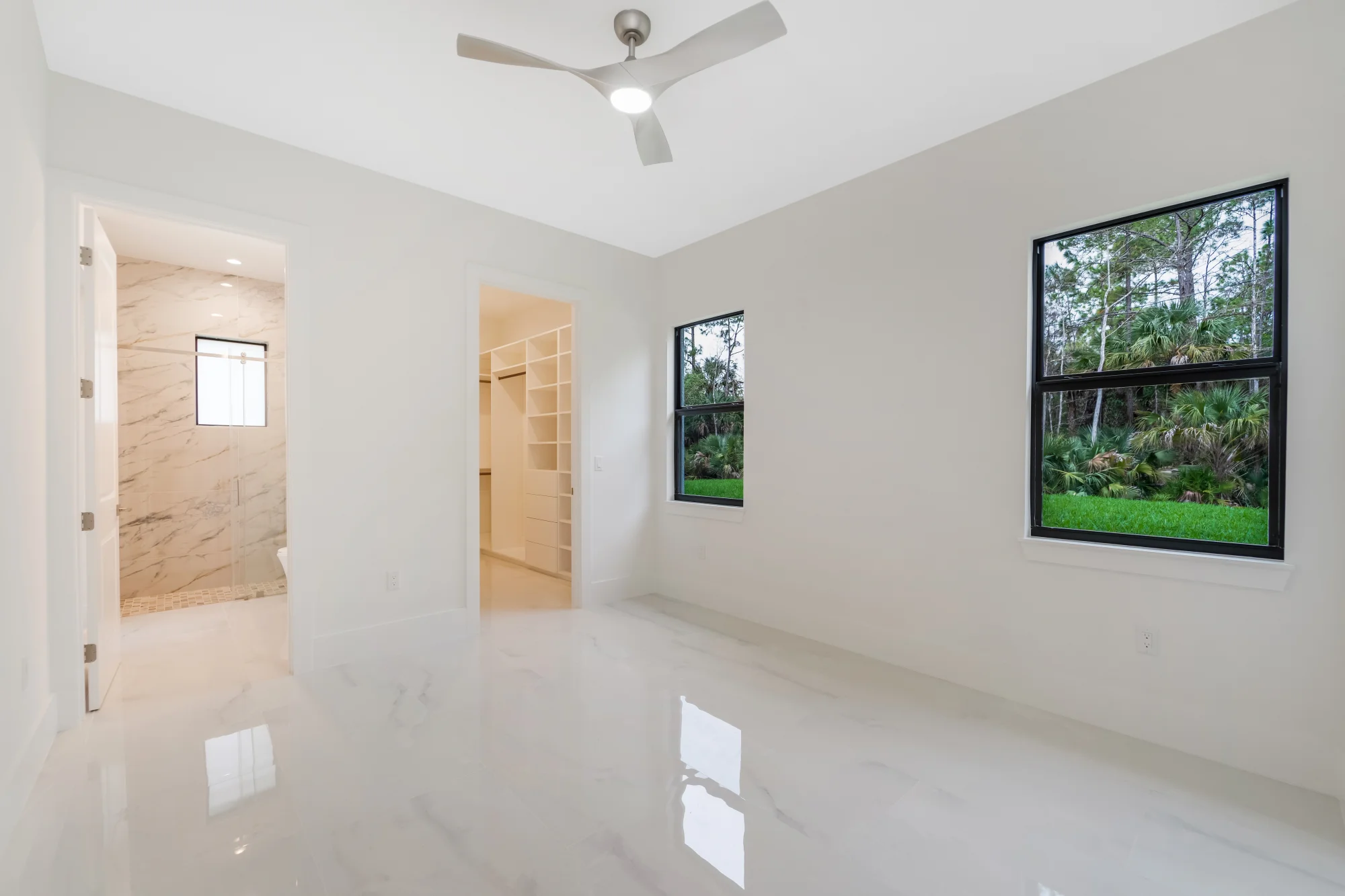 Spacious master suite with tray ceiling and custom millwork in Sunset Golf modern golf estate home at 524 22nd Ave NW, Naples FL by XL Homes custom home builder