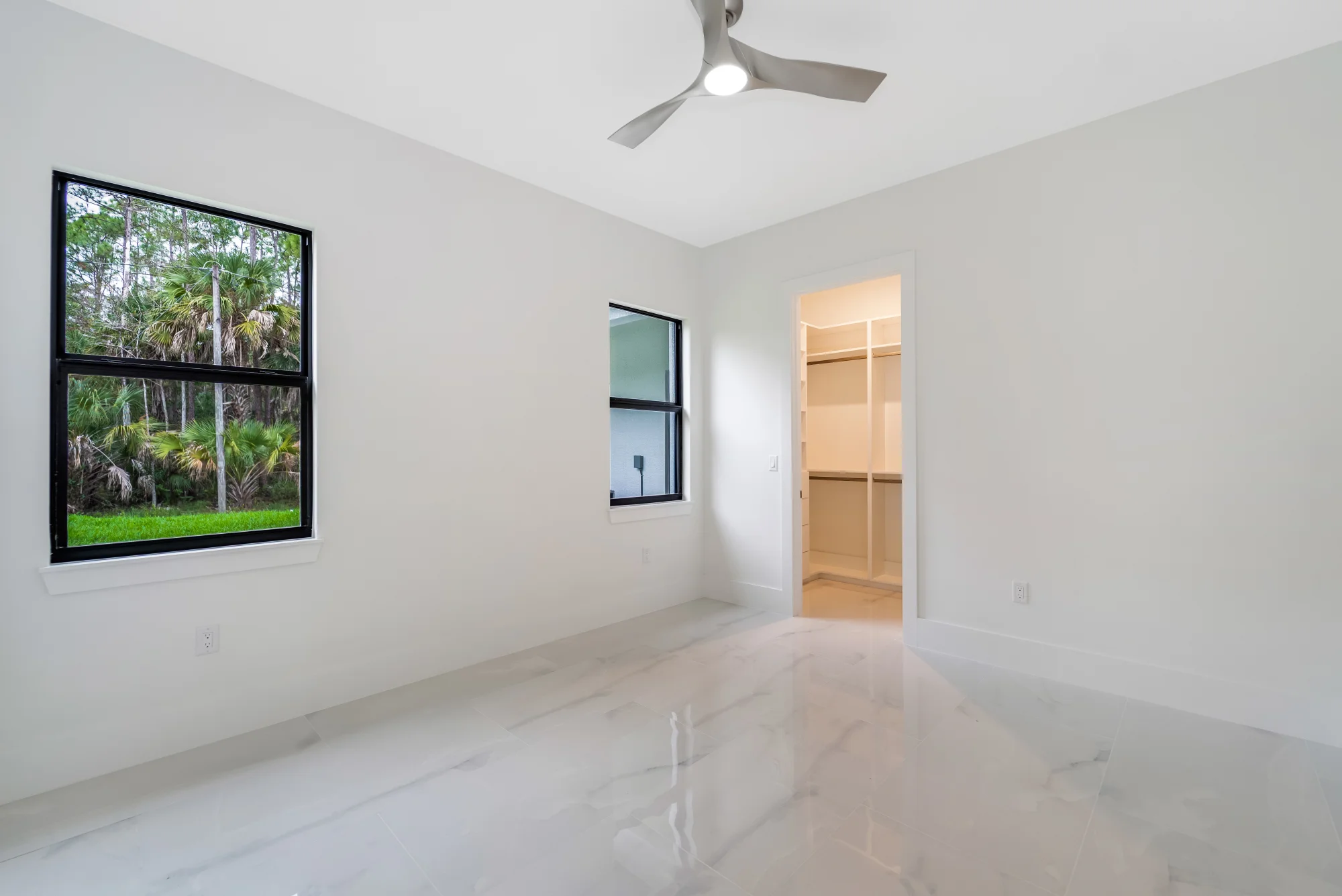 Spacious master suite with tray ceiling and custom millwork in Sunset Golf modern golf estate home at 524 22nd Ave NW, Naples FL by XL Homes custom home builder