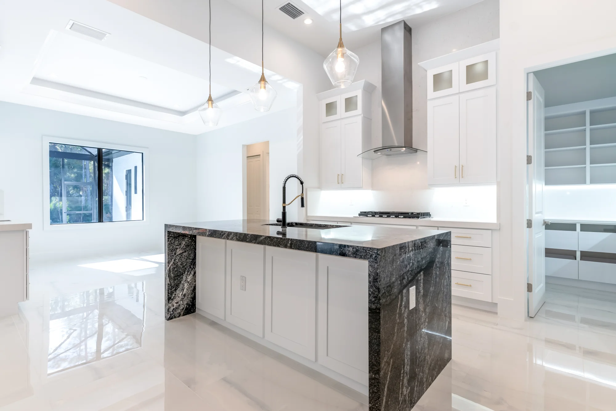 Gourmet kitchen with quartz countertops and custom cabinetry in Sunset Golf modern golf estate home at 524 22nd Ave NW, Naples FL by XL Homes custom home builder
