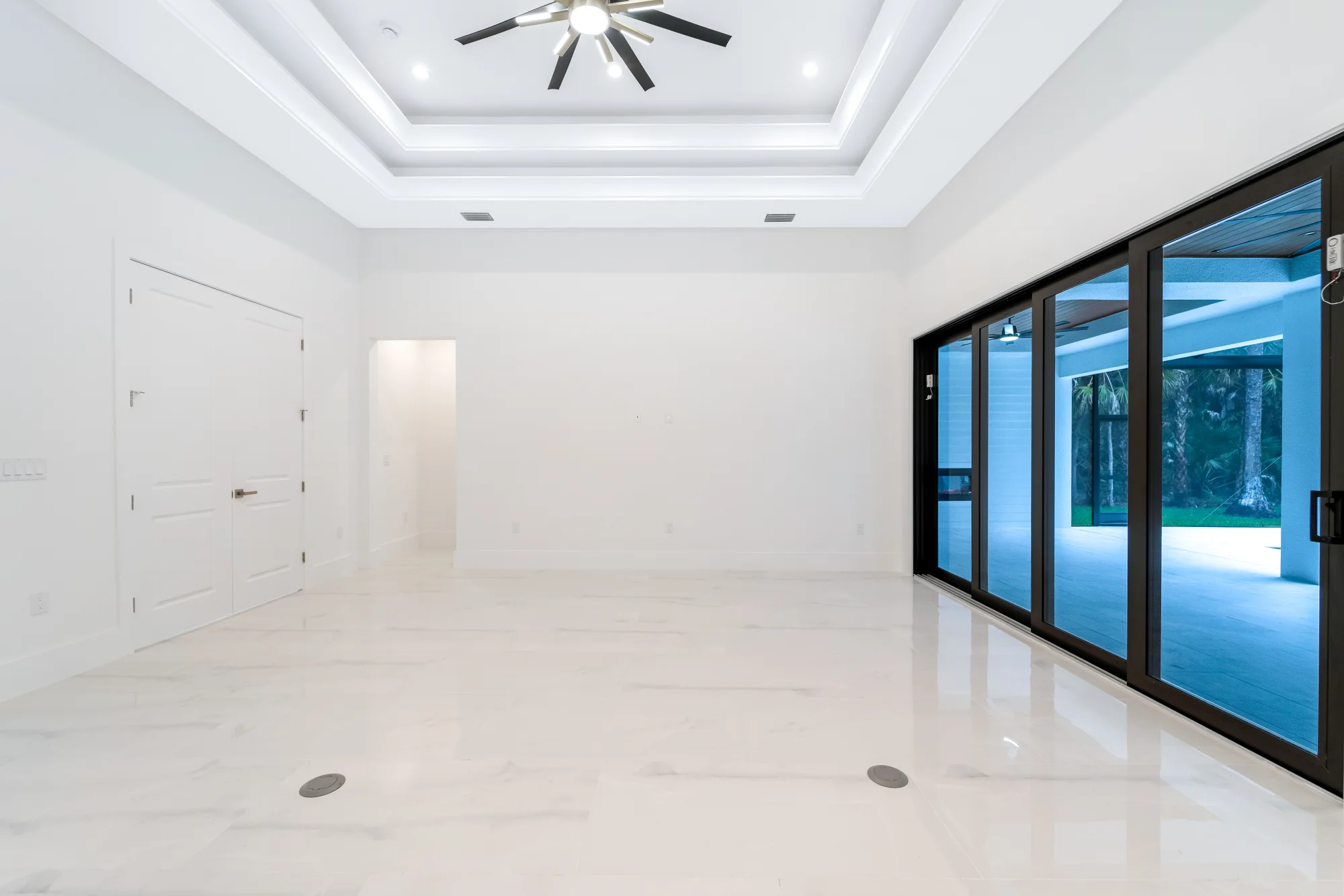 Open concept living room with high ceilings and natural light in Sunset Golf modern golf estate home at 524 22nd Ave NW, Naples FL by XL Homes custom home builder
