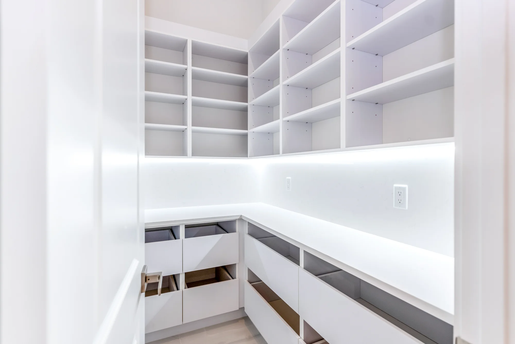 Walk-in pantry with custom shelving and organization in Sunset Golf modern golf estate home at 524 22nd Ave NW, Naples FL by XL Homes custom home builder