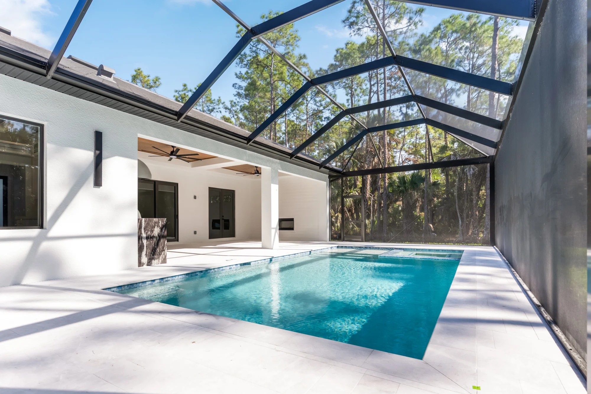 Resort-style pool and screened lanai with outdoor living space in Sunset Golf modern golf estate home at 524 22nd Ave NW, Naples FL by XL Homes custom home builder
