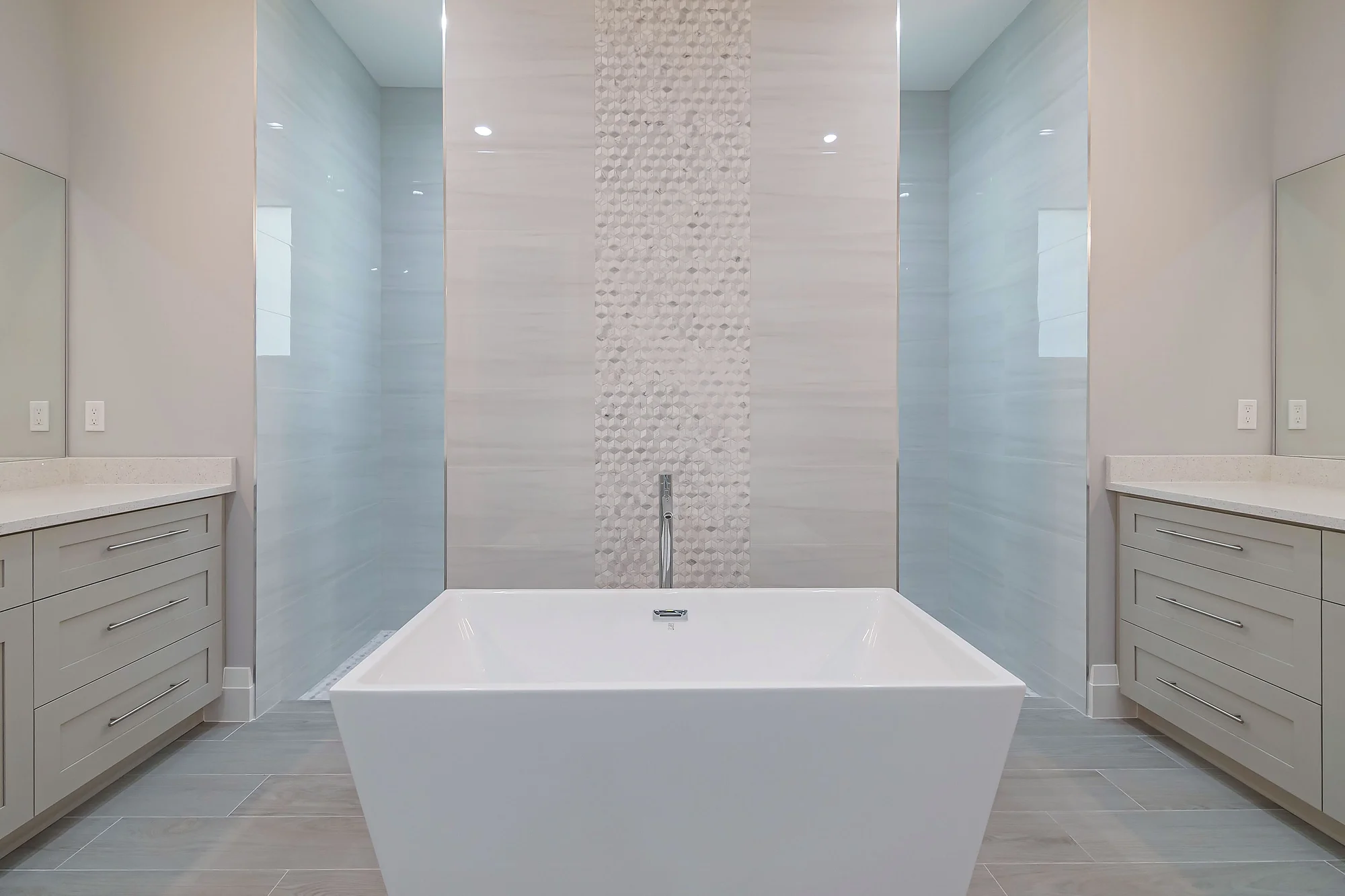 Luxury spa bathroom with marble tiles and designer fixtures in The Oasis coastal contemporary home at 760 15th St SW, Naples FL by XL Homes custom home builder