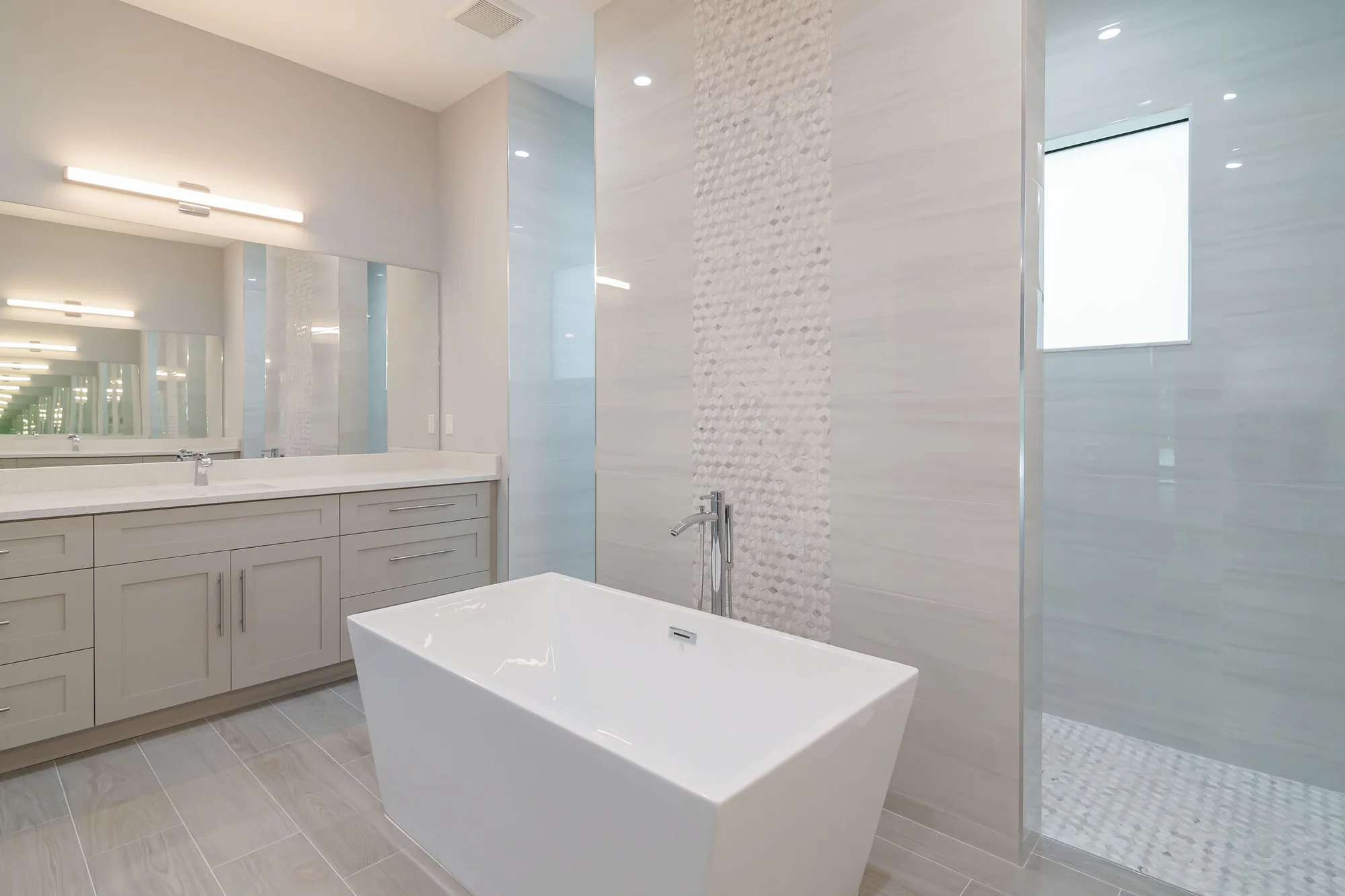Luxury spa bathroom with marble tiles and designer fixtures in The Oasis coastal contemporary home at 760 15th St SW, Naples FL by XL Homes custom home builder