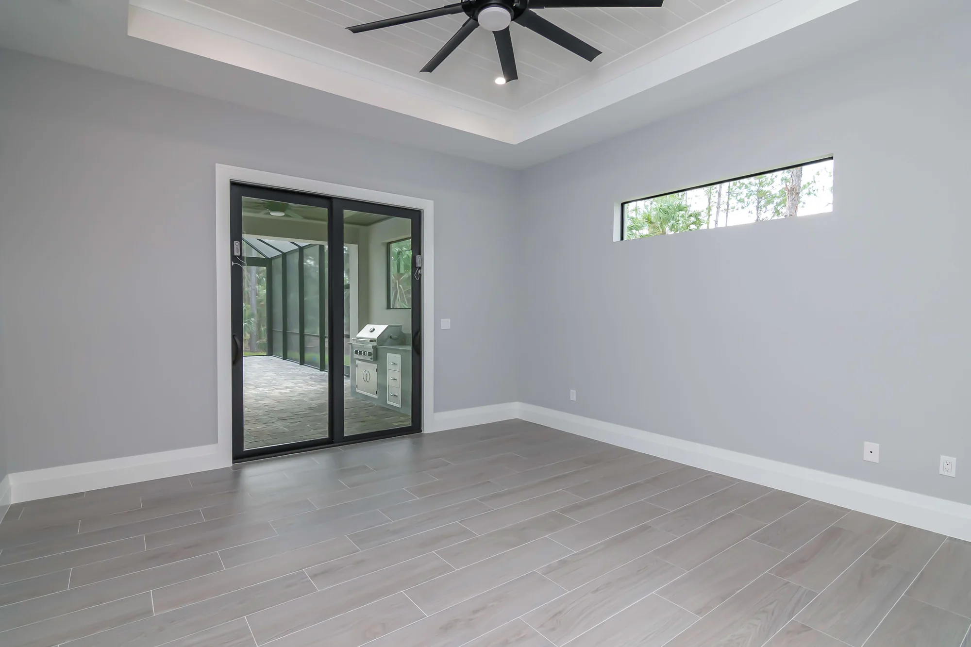 Spacious master suite with tray ceiling and custom millwork in The Oasis coastal contemporary home at 760 15th St SW, Naples FL by XL Homes custom home builder