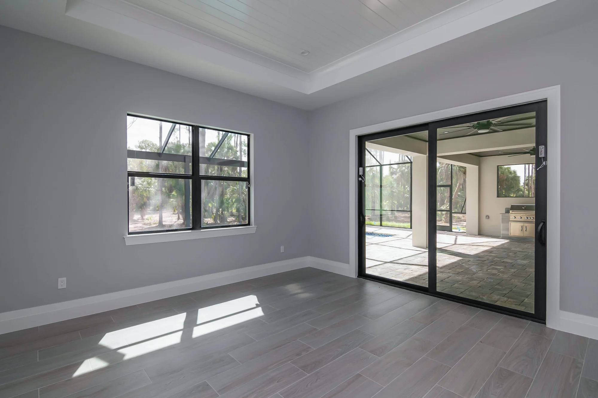 Elegant formal dining room with coffered ceiling in The Oasis coastal contemporary home at 760 15th St SW, Naples FL by XL Homes custom home builder