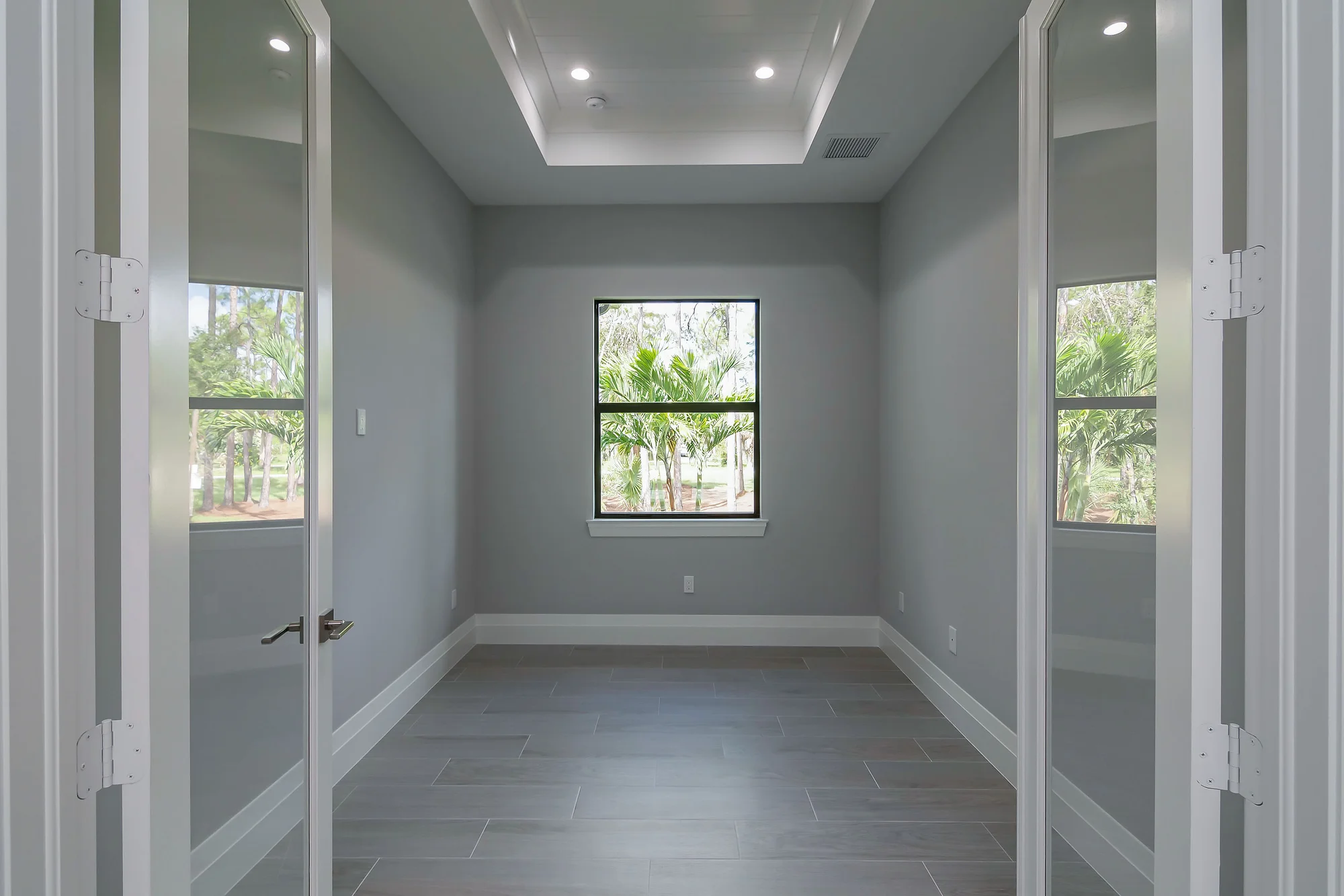 Executive home office with built-in shelving and desk in The Oasis coastal contemporary home at 760 15th St SW, Naples FL by XL Homes custom home builder