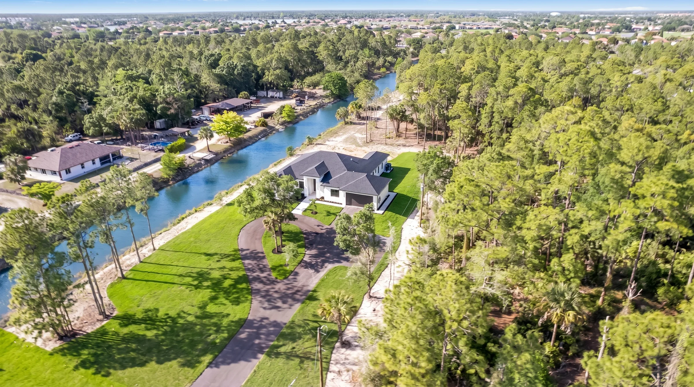 Aerial drone view showcasing luxury estate and neighborhood in Rookery Bay transitional coastal luxury home at Naples, FL by XL Homes custom home builder