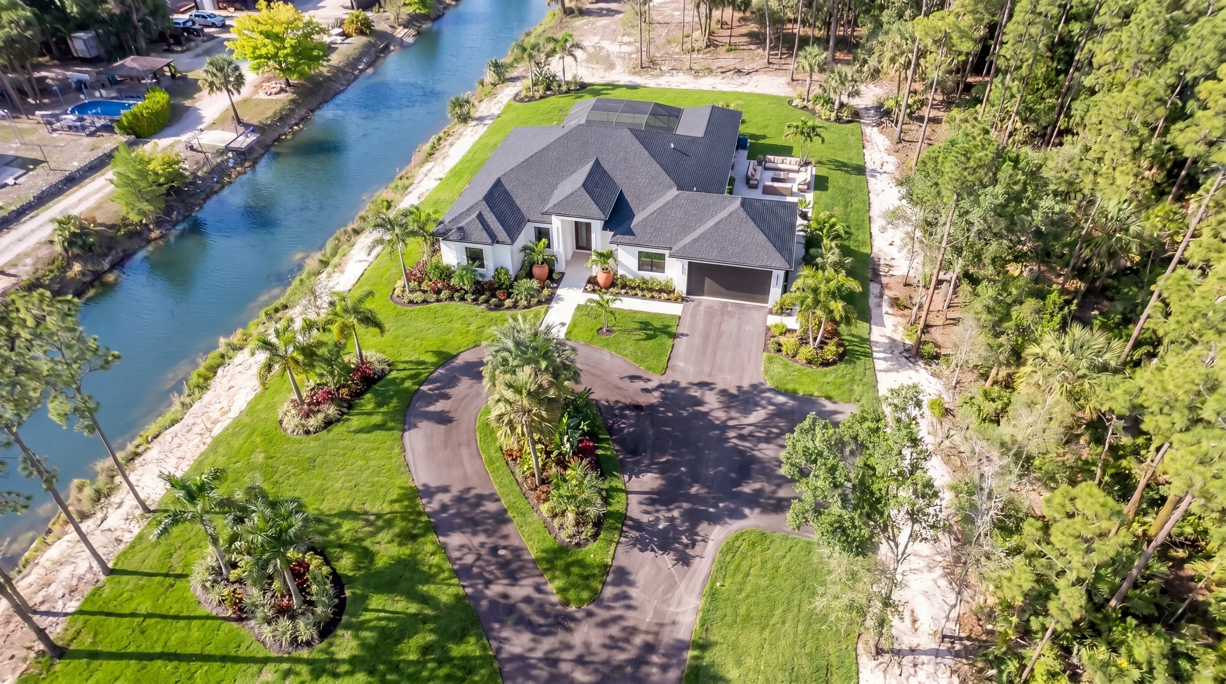 Aerial drone view showcasing luxury estate and neighborhood in Rookery Bay transitional coastal luxury home at Naples, FL by XL Homes custom home builder