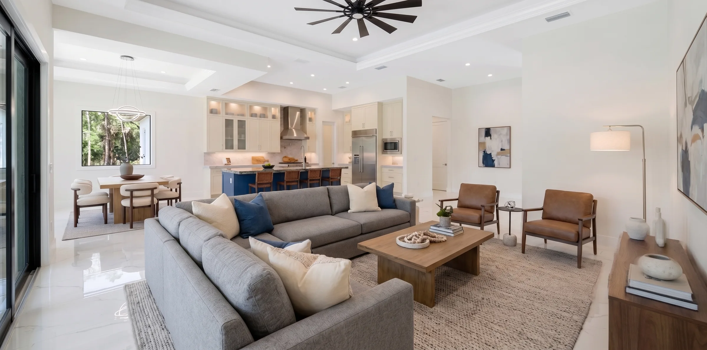 Open concept living room with high ceilings and natural light in Rookery Bay transitional coastal luxury home at Naples, FL by XL Homes custom home builder