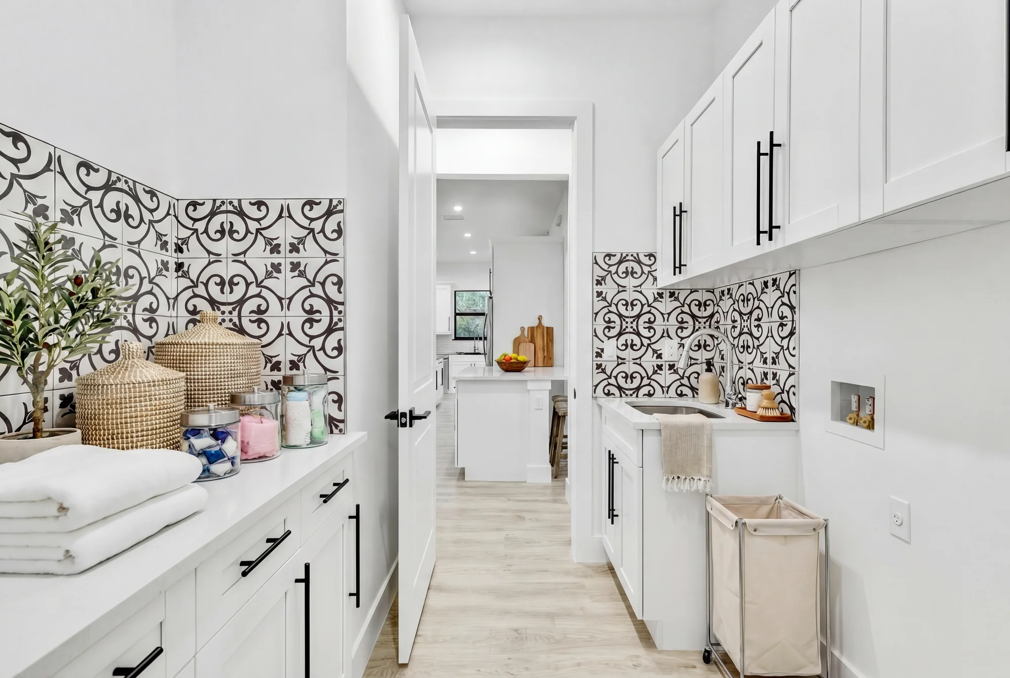 Premium laundry room with quartz countertops and cabinetry in The Modern Haven modern minimalist home at 2747 6th Ave NE, Naples FL by XL Homes custom home builder