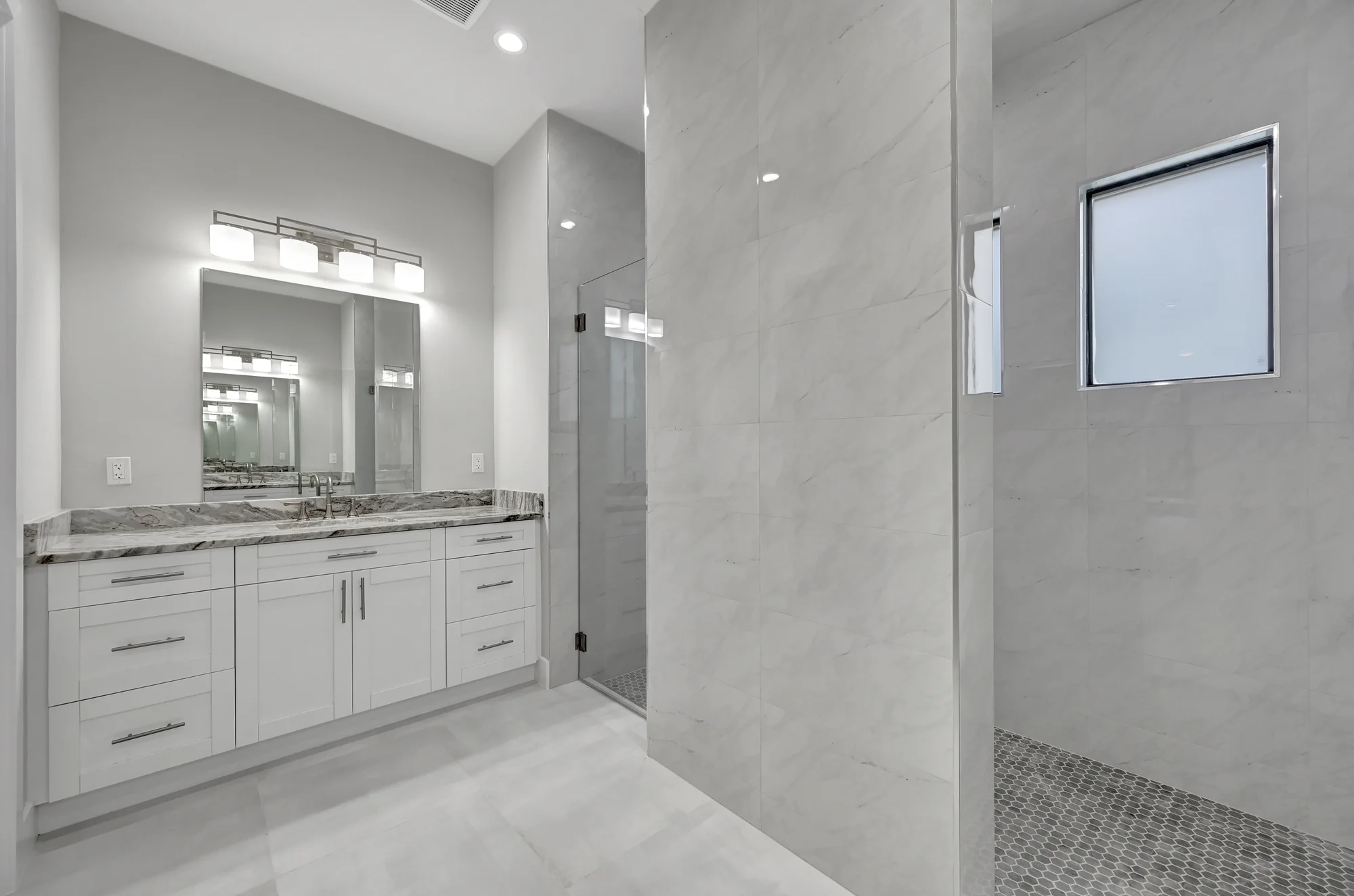Luxury spa bathroom with marble tiles and designer fixtures in The Panorama Florida contemporary home at 70 33rd Ave NW, Naples FL by XL Homes custom home builder