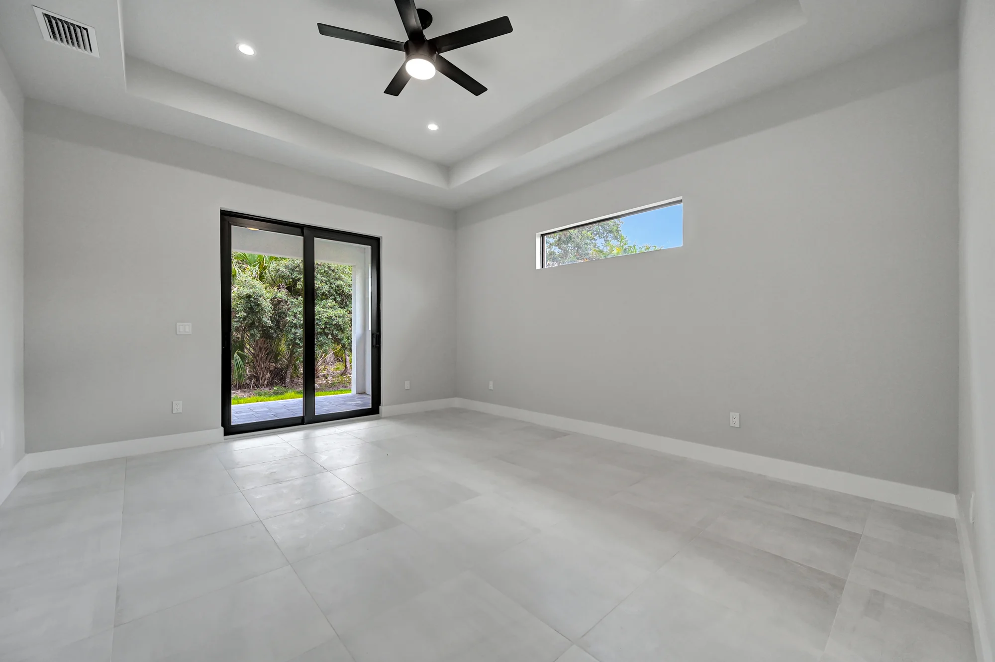 Spacious master suite with tray ceiling and custom millwork in The Panorama Florida contemporary home at 70 33rd Ave NW, Naples FL by XL Homes custom home builder