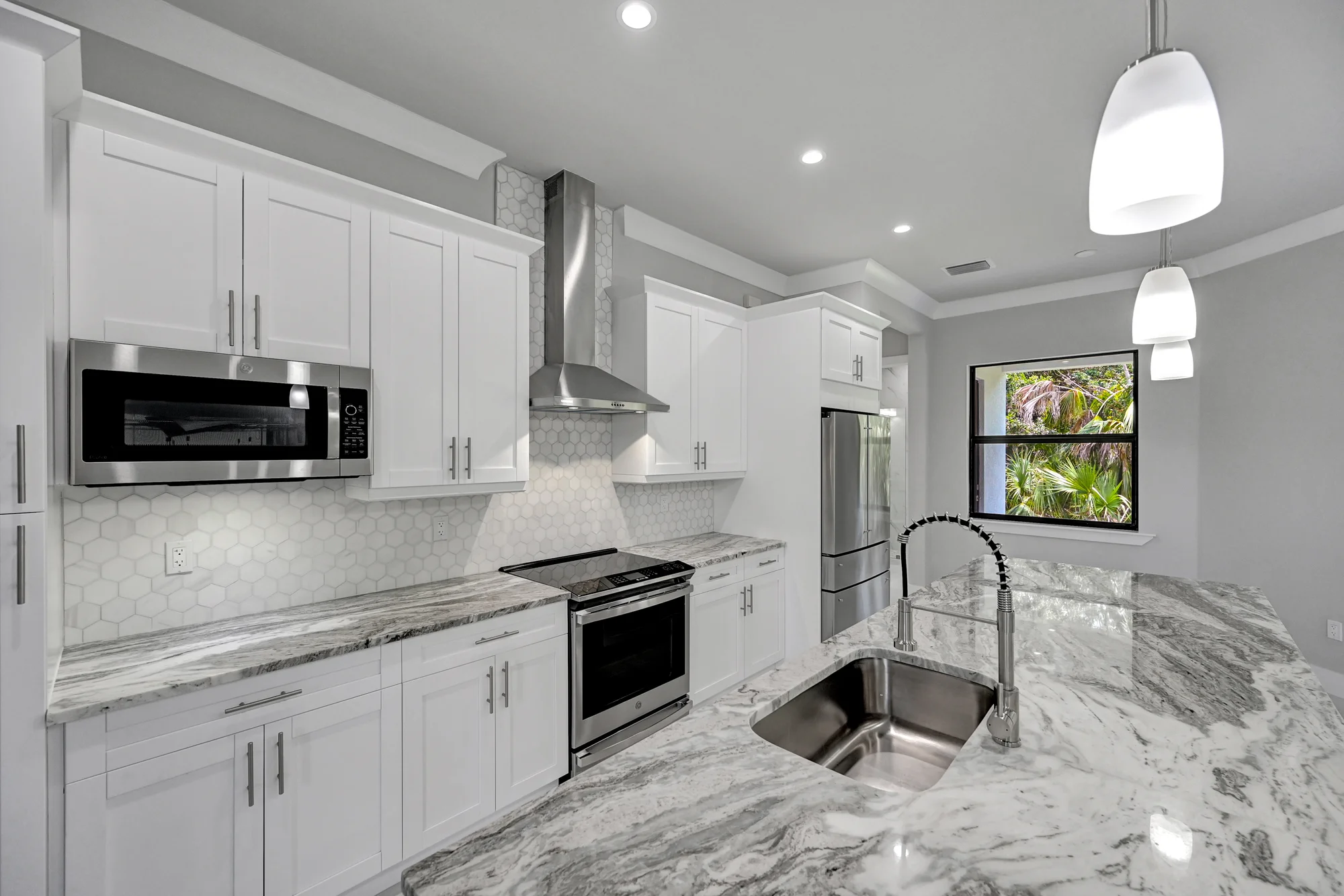 Gourmet kitchen with quartz countertops and custom cabinetry in The Panorama Florida contemporary home at 70 33rd Ave NW, Naples FL by XL Homes custom home builder