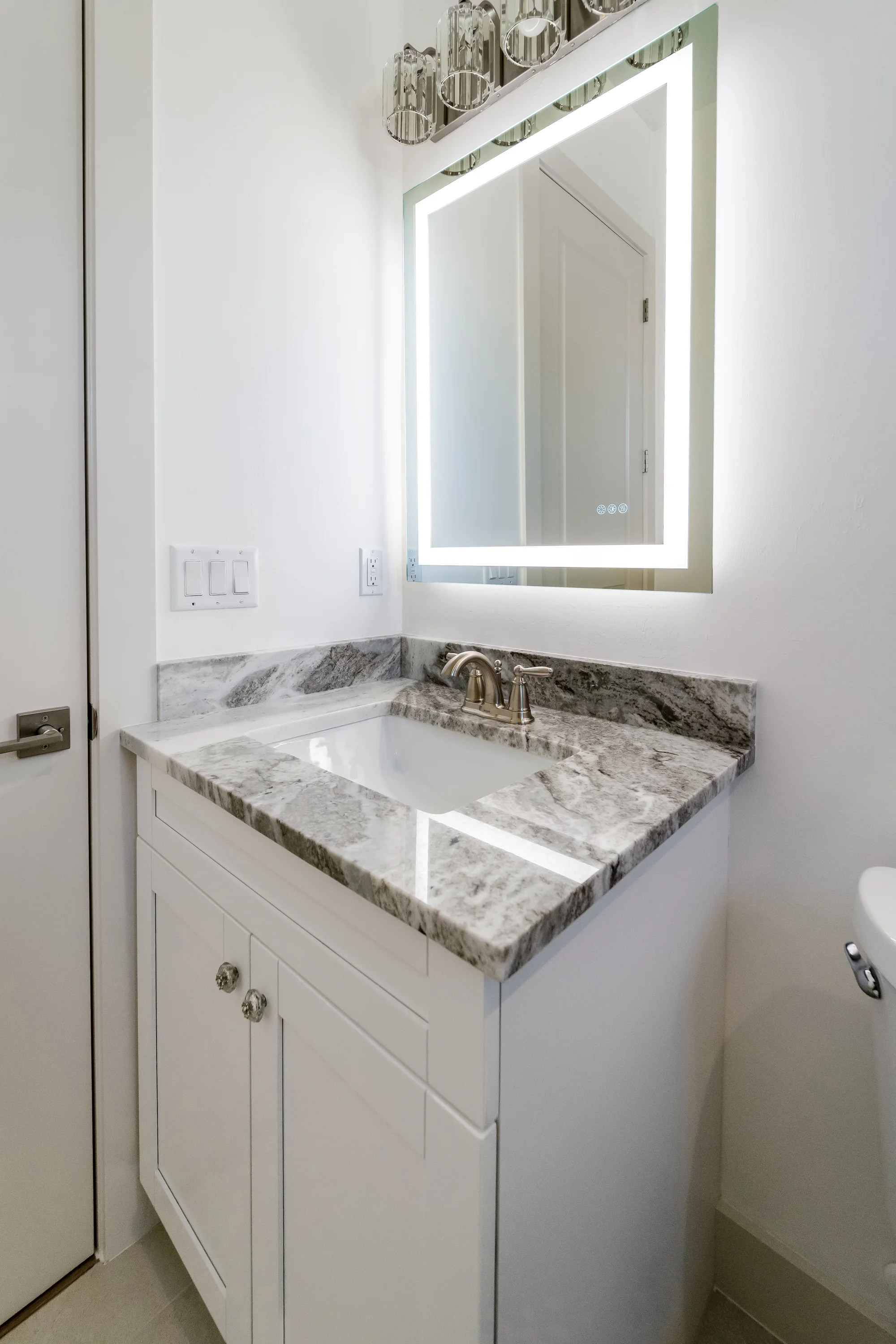 Luxury spa bathroom with marble tiles and designer fixtures in The Sapphire contemporary waterfront home at 619 22nd St SE, Naples FL by XL Homes custom home builder
