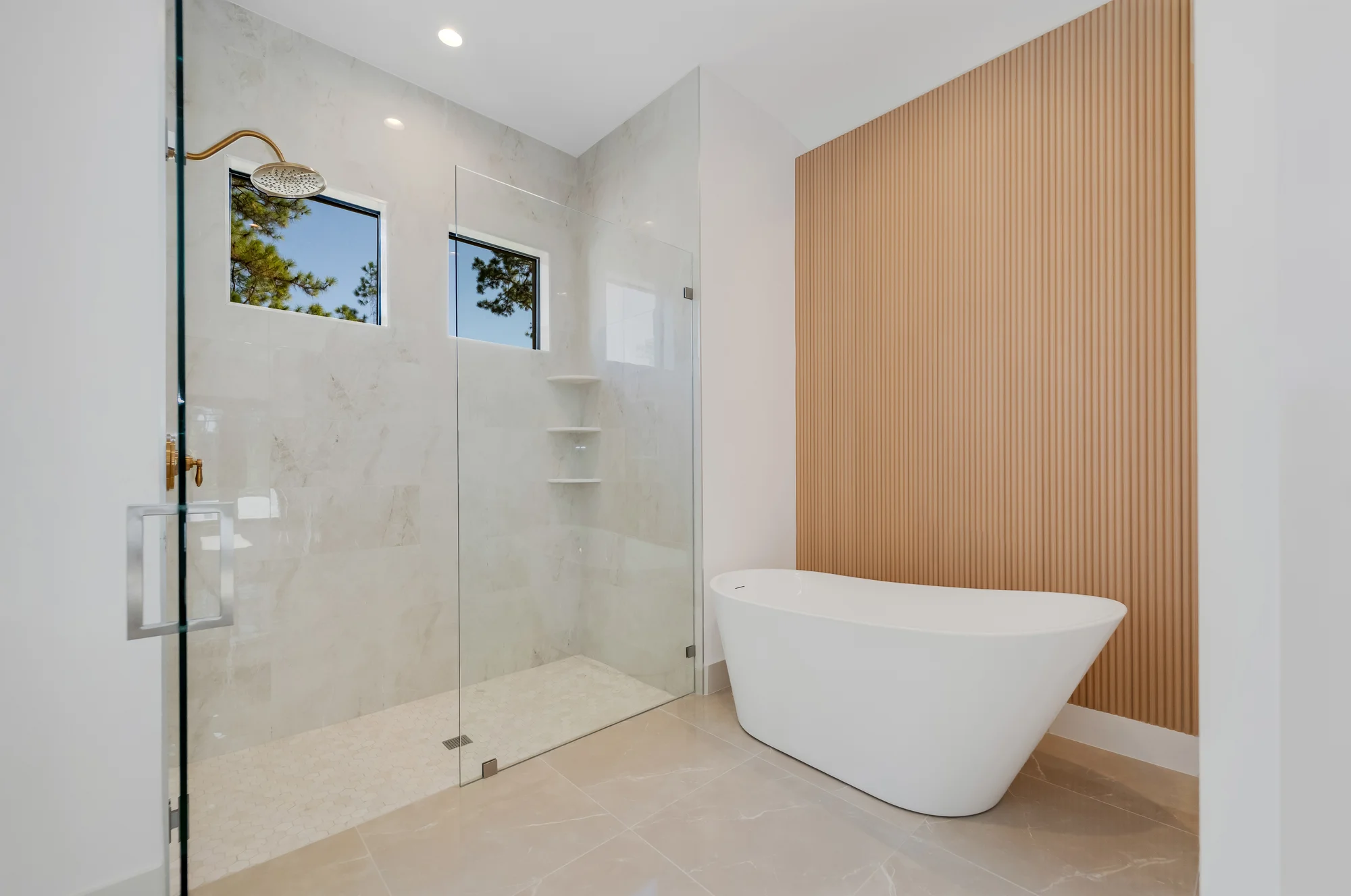 Luxury spa bathroom with marble tiles and designer fixtures in The Sapphire contemporary waterfront home at 619 22nd St SE, Naples FL by XL Homes custom home builder