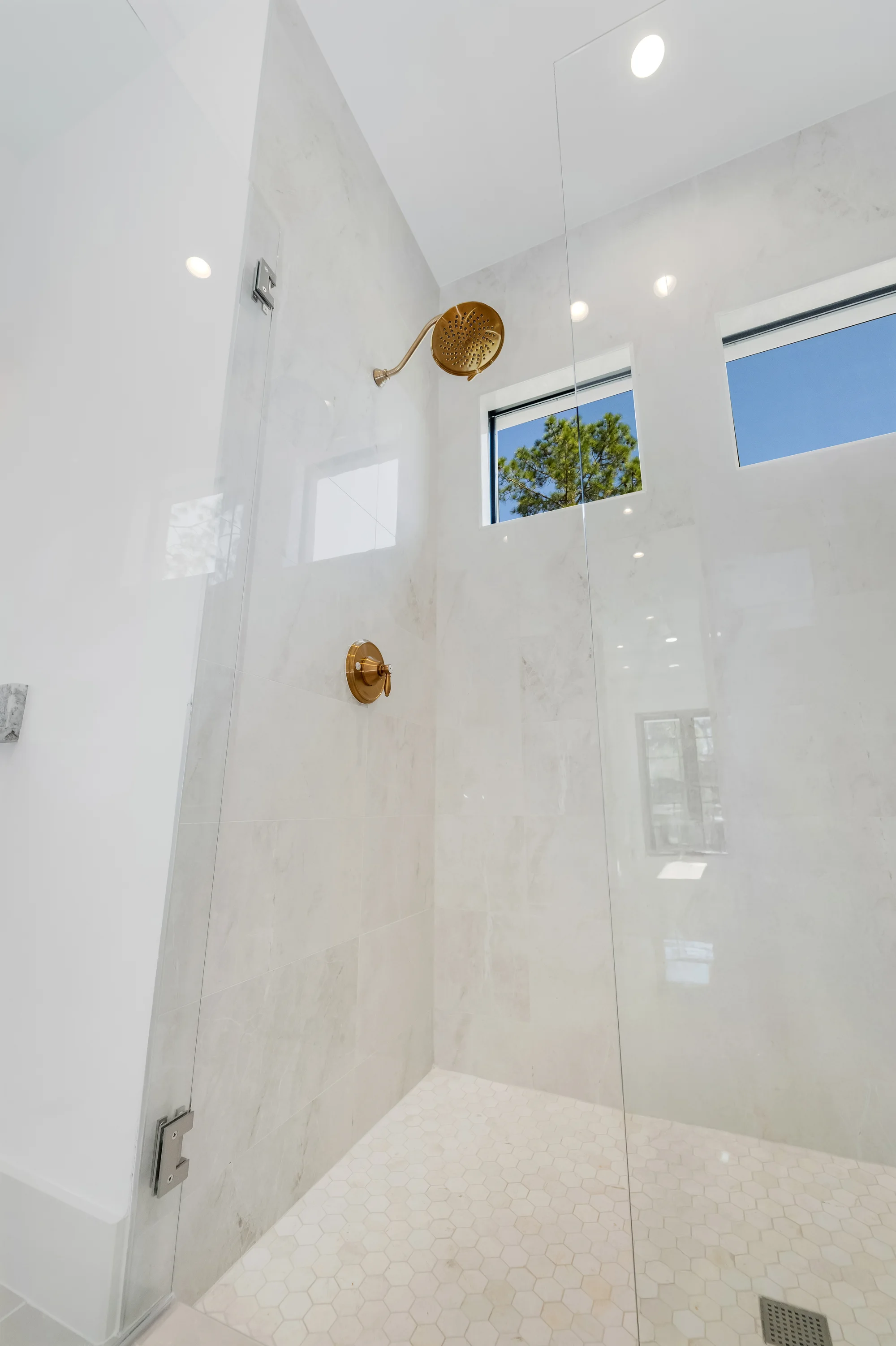 Luxury spa bathroom with marble tiles and designer fixtures in The Sapphire contemporary waterfront home at 619 22nd St SE, Naples FL by XL Homes custom home builder