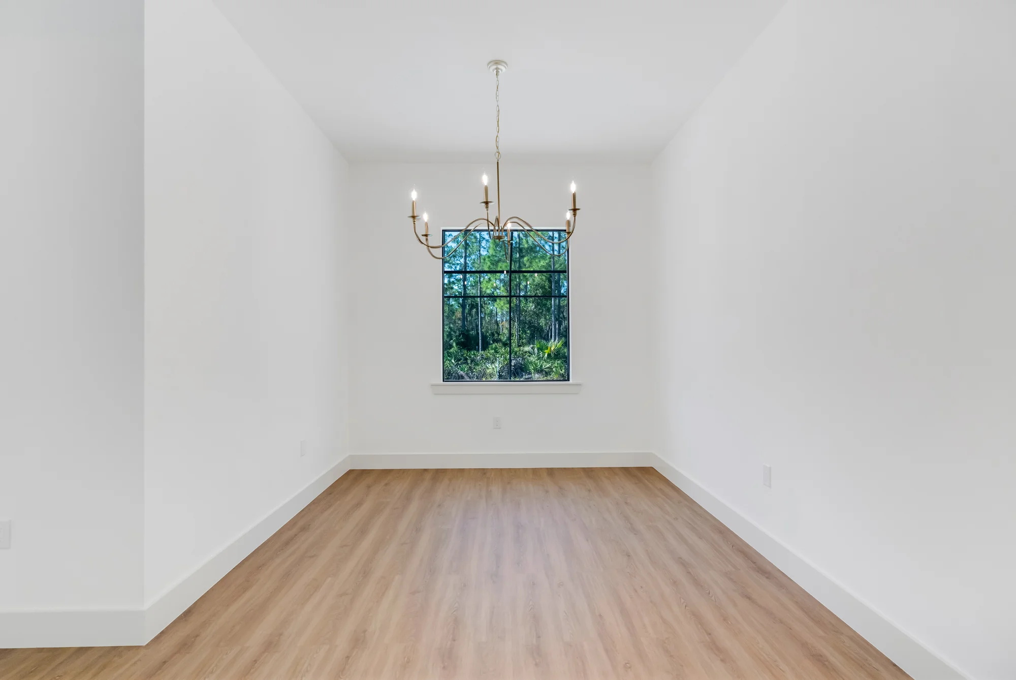 Elegant formal dining room with coffered ceiling in The Sapphire contemporary waterfront home at 619 22nd St SE, Naples FL by XL Homes custom home builder