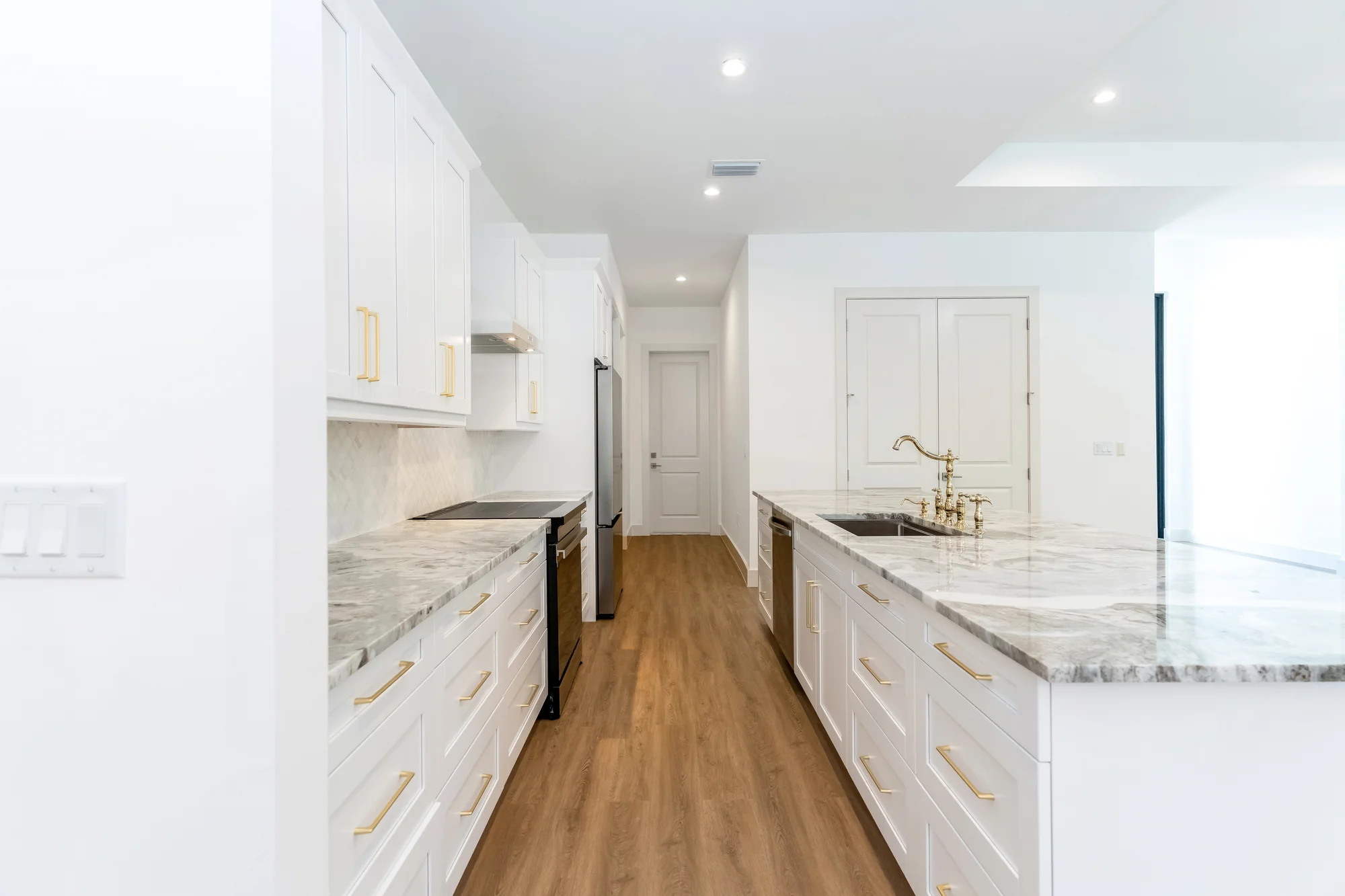 Gourmet kitchen with quartz countertops and custom cabinetry in The Sapphire contemporary waterfront home at 619 22nd St SE, Naples FL by XL Homes custom home builder