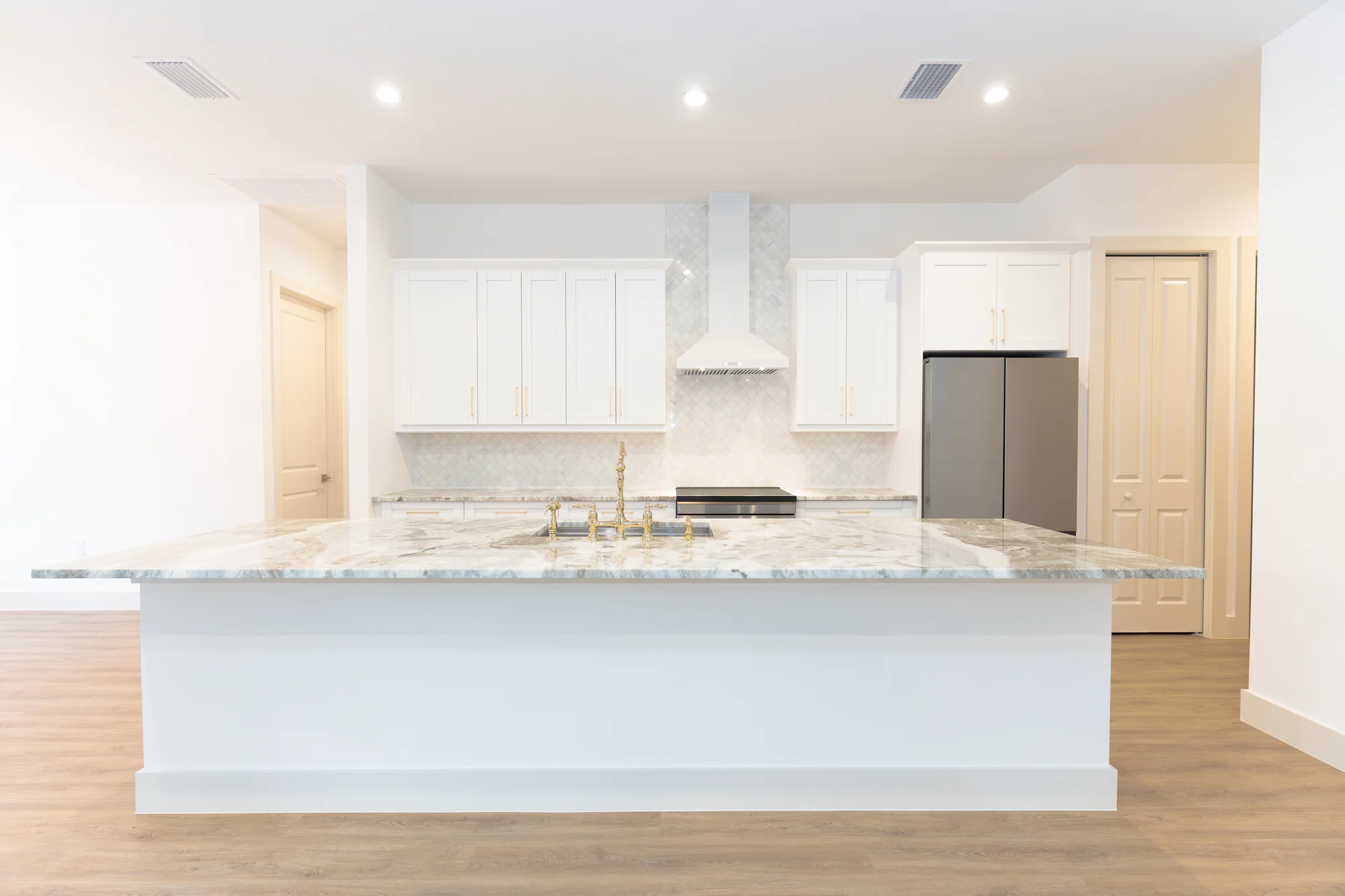 Gourmet kitchen with quartz countertops and custom cabinetry in The Sapphire contemporary waterfront home at 619 22nd St SE, Naples FL by XL Homes custom home builder