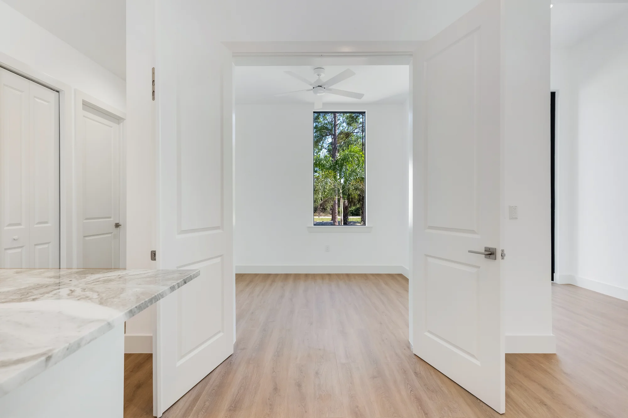 Executive home office with built-in shelving and desk in The Sapphire contemporary waterfront home at 619 22nd St SE, Naples FL by XL Homes custom home builder